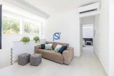 a white living room with a couch and two pillows at Villa Irene Deluxe in Campofelice di Roccella