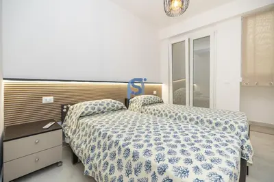 a bedroom with a bed with a blue and white comforter at Villa Irene Deluxe in Campofelice di Roccella