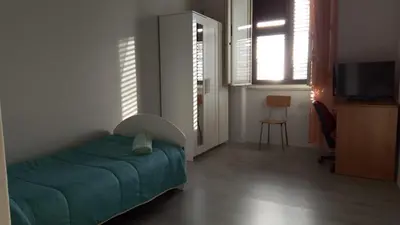 a bedroom with a bed and a television in it at La casetta della stazione in Palermo