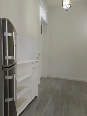 a kitchen with white cabinets and a stainless steel refrigerator at La casetta della stazione in Palermo