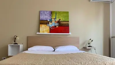 a bedroom with a bed with a painting on the wall at Marrakech Home in Palermo