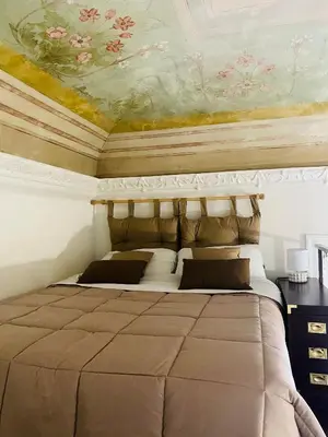 a bedroom with a bed with a painting on the ceiling at Politeama House in Palermo