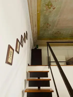 a staircase with a painting on the wall and a stair case at Politeama House in Palermo