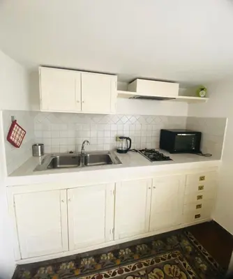 a kitchen with white cabinets and a sink at Politeama House in Palermo