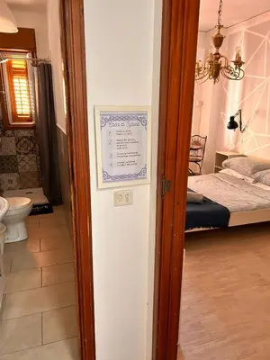 a room with a bed and a sign on a wall at Casa di Sylwia in Termini Imerese