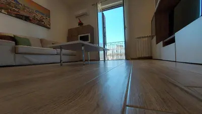 a living room with a table on a wooden floor at Amedeo Suite - Palermo Centro in Palermo