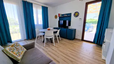 a living room with a table and chairs at Villa Lilia - Private pool in Campofelice di Roccella