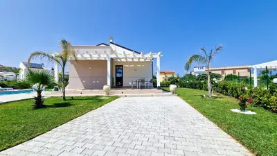 a house with a walkway in front of a yard at Villa Lilia - Private pool in Campofelice di Roccella