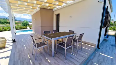a patio with a table and chairs on a deck at Villa Lilia - Private pool in Campofelice di Roccella
