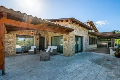 a stone house with a patio with chairs at Villa DelMarmo in Alcamo