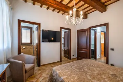 a bedroom with a large bed and a chandelier at Villa DelMarmo in Alcamo