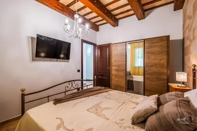 a bedroom with a bed with a tv on the wall at Villa DelMarmo in Alcamo