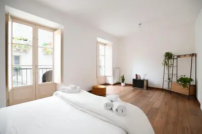 a white bedroom with a large bed with two towels at iFlat Le stanze del Principe in Palermo