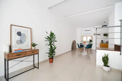 a white living room with a table and plants at iFlat Le stanze del Principe in Palermo