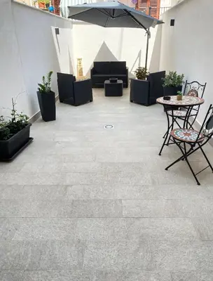 a patio with a table and chairs and an umbrella at Yris House in Palermo