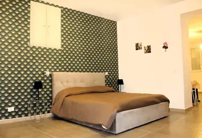 a bedroom with a bed and a wall with polka dots at MARICCHIA per SAITTA HOLIDAYS in Palermo