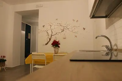 a kitchen with a table and a tree on the wall at MARICCHIA per SAITTA HOLIDAYS in Palermo