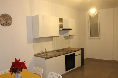 a kitchen with white cabinets and a table and a clock at MARICCHIA per SAITTA HOLIDAYS in Palermo