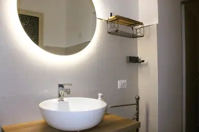 a bathroom with a white sink and a mirror at MARICCHIA per SAITTA HOLIDAYS in Palermo