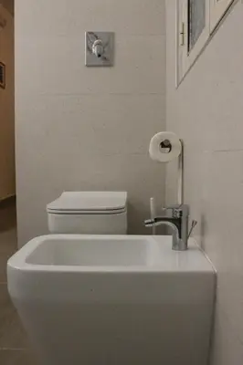 a white bathroom with a toilet and a sink at MARICCHIA per SAITTA HOLIDAYS in Palermo