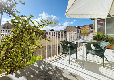 a patio with two chairs and a table on a deck at Solemar Sicilia - Terrazza del Merlo in Palermo