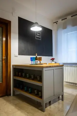 a kitchen with a counter with bottles of wine on it at Nanà Apartment in Palermo