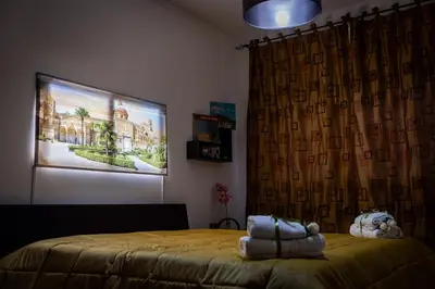 a bedroom with a bed and a painting on the wall at Nanà Apartment in Palermo