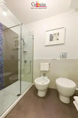 a bathroom with a toilet and a glass shower at B&B Cubbaita in Palermo