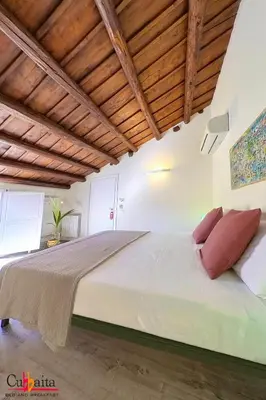 a large bed in a room with wooden ceilings at B&B Cubbaita in Palermo