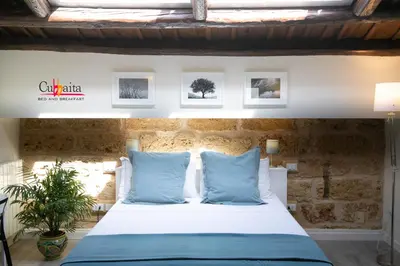 a bedroom with a bed with blue pillows at B&B Cubbaita in Palermo