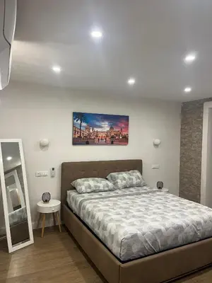 a bedroom with a bed and a painting on the wall at Lolli House in Palermo