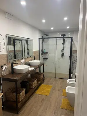 a bathroom with two sinks and a glass shower at Lolli House in Palermo