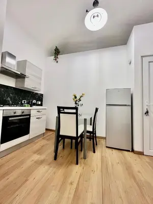 a kitchen with a table and two chairs and a refrigerator at Mediterranea sole in Palermo