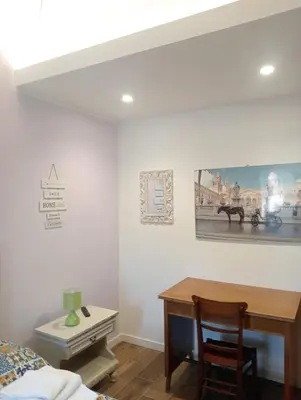 a bedroom with a desk and a bed and a table at MONDELLO JUNO'S ROOMS in Mondello