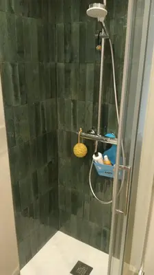 a shower with a green tiled wall in a bathroom at MONDELLO JUNO'S ROOMS in Mondello