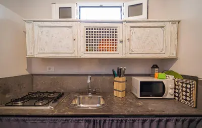 a kitchen counter with a sink and a microwave at Oasi Relax - Romantic Room & Spa in Torretta