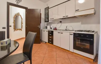 a kitchen with white cabinets and a black stove top oven at Gorgeous Apartment In Palermo With Wifi in Palermo