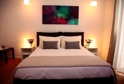 a bedroom with a large bed with two tables and two lamps at B&B Massimo Inn in Palermo