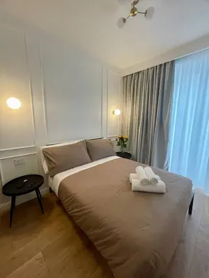 a bedroom with a large bed with two towels on it at Politeama's Home - Luxury Apartment in Palermo