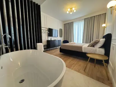 a bathroom with a tub and a bedroom with a bed at Politeama's Home - Luxury Apartment in Palermo