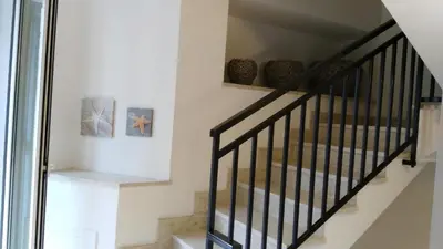 a staircase with black railings and vases on the wall at Affittacamere Amunì in Castellammare del Golfo