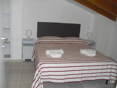 a bedroom with a large bed with two towels at Affittacamere Amunì in Castellammare del Golfo