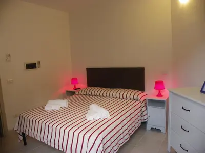 a bedroom with two beds with pink lamps on them at Affittacamere Amunì in Castellammare del Golfo