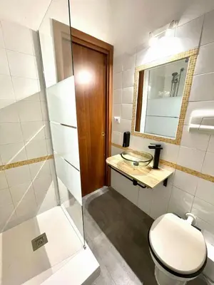 a bathroom with a toilet and a glass shower at Vicolo 20 in Palermo