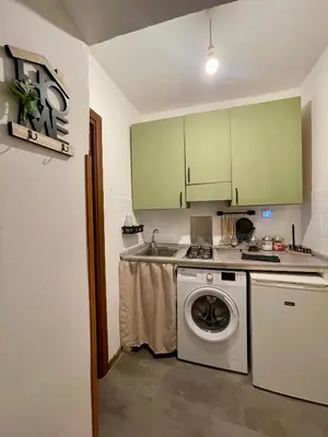 a kitchen with green cabinets and a washing machine at Vicolo 20 in Palermo