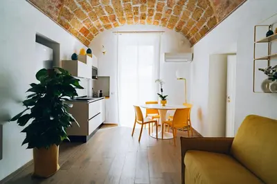 a living room with a table and a kitchen at Giardino del Foro in Palermo