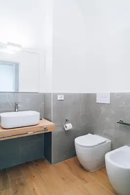a bathroom with a sink and a toilet and a mirror at Giardino del Foro in Palermo