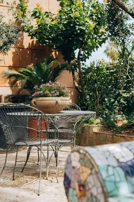 a table and chairs with a bowl of flowers on it at Giardino della Kalsa in Palermo