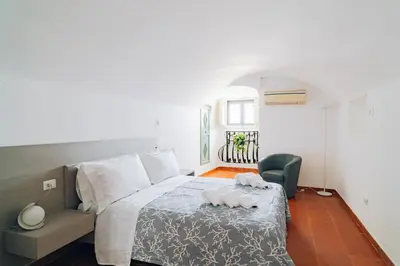 a bedroom with a bed and a chair at Giardino della Kalsa in Palermo