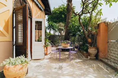 a patio with a table and chairs and a white door at Giardino della Kalsa in Palermo